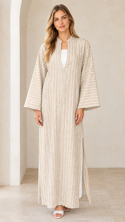 Woman wearing beige neutral vertical striped maxi kaftan dress