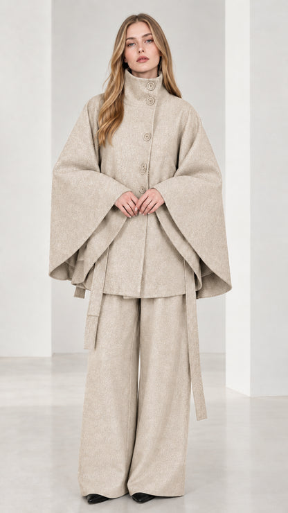 Front view of beige cream high neck belted cape coat and wide-leg trousers set