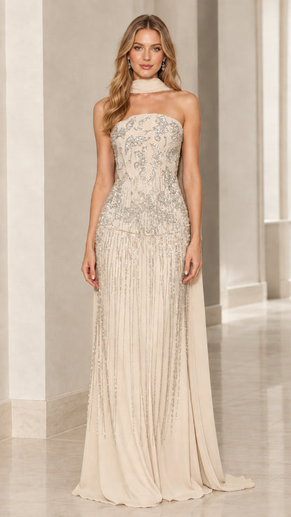 Model wearing champagne ivory strapless beaded formal gown with long scarf drape