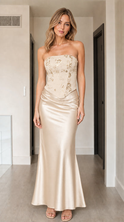 Front view of woman wearing champagne gold strapless sequin corset satin maxi dress