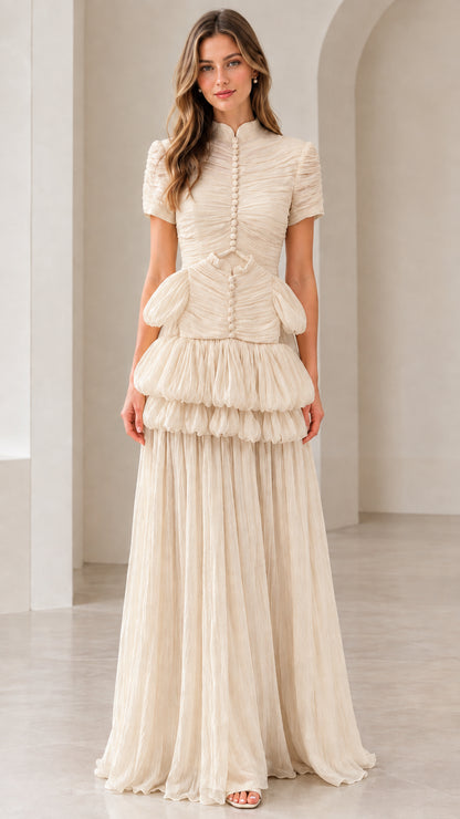 Front view of model wearing champagne beige mock neck tiered pleated maxi dress