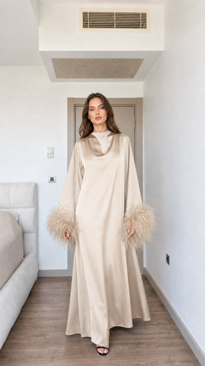 Model wearing elegant champagne beige satin maxi dress with feather cuffs