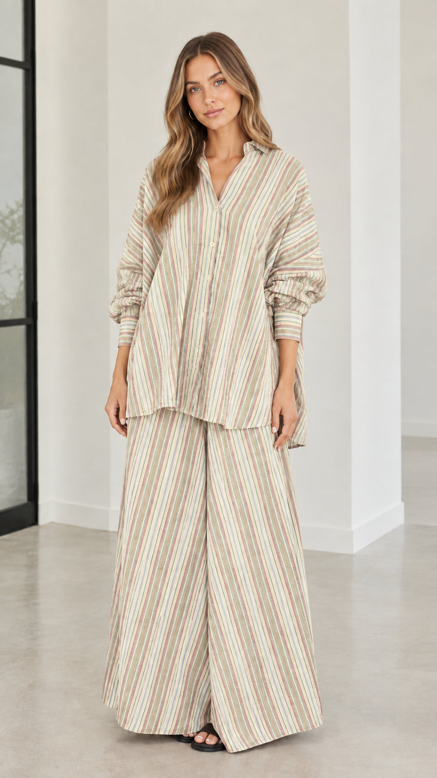 Model wearing beige and neutral striped oversized tunic shirt and wide-leg pants set