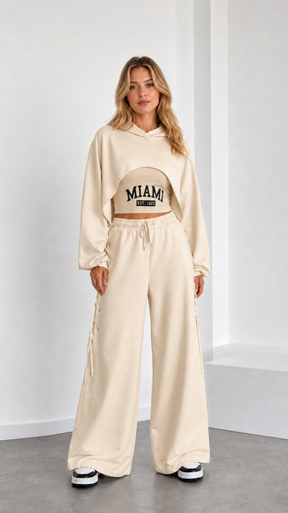 Model wearing beige 3-piece cropped hoodie and wide leg lounge set