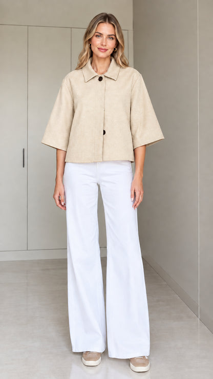 Front view of a woman wearing the cropped half-sleeve swing jacket in beige