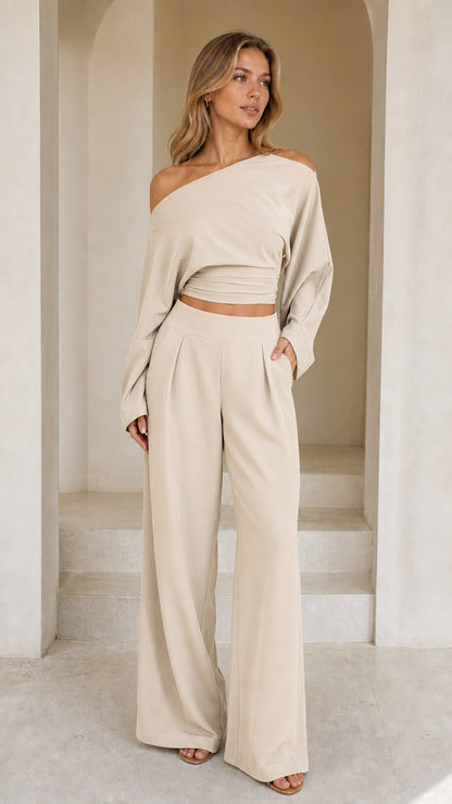 Full front view of model wearing beige off-shoulder crop top and wide-leg pant set