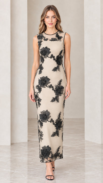 Model wearing champagne beige dress with contrast black floral appliqué