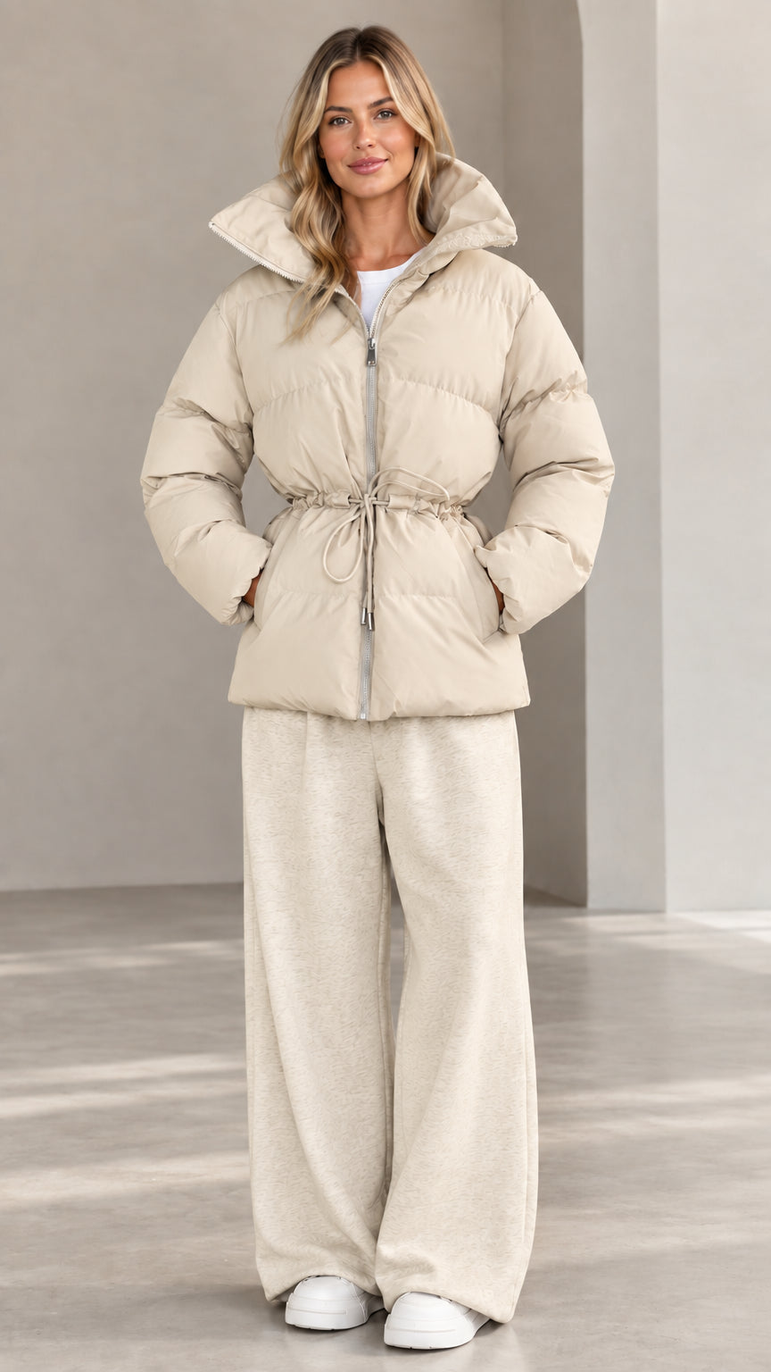 Front view of woman wearing warm beige hooded cinch-waist puffer jacket