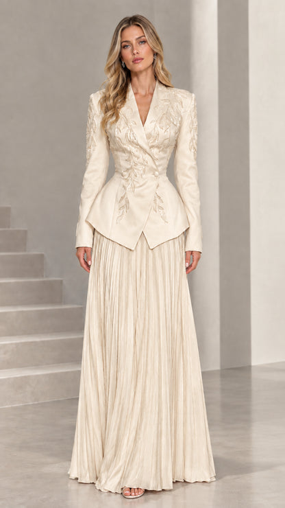 Full-length view of champagne ivory embroidered peplum blazer and pleated maxi skirt