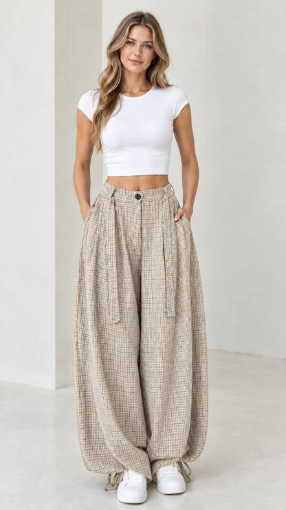 Front view of woman wearing beige oatmeal micro-plaid wide leg pleated pants