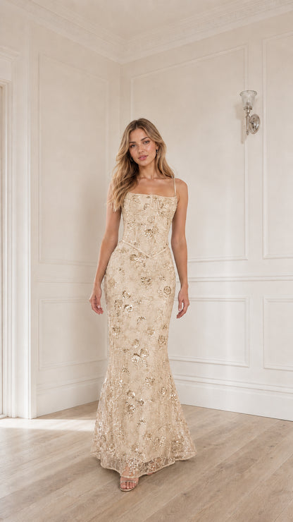 Woman wearing champagne sequin embroidered corset maxi dress
