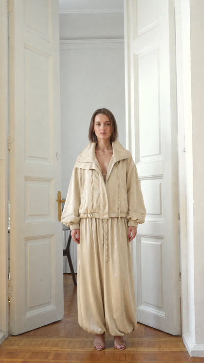 Front view of model wearing neutral beige relaxed two-piece tracksuit set