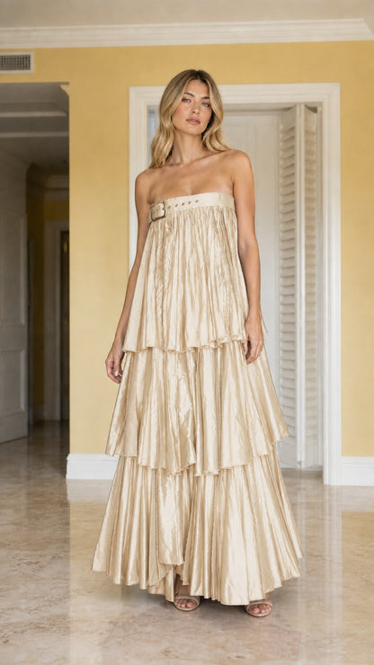 Front view of model wearing champagne gold strapless tiered pleated maxi dress